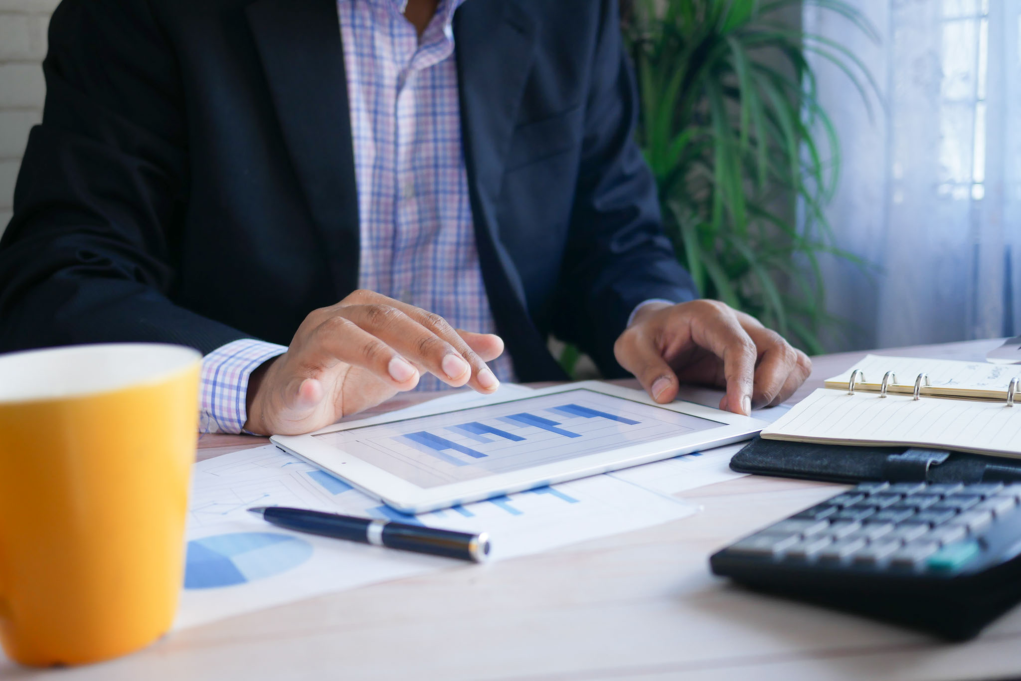 A business manager checks his budgets on a tablet