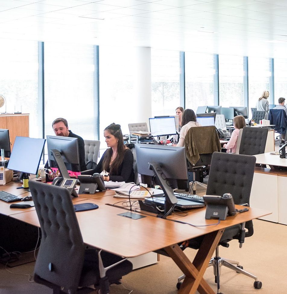 A busy public sector office with employees using new computers