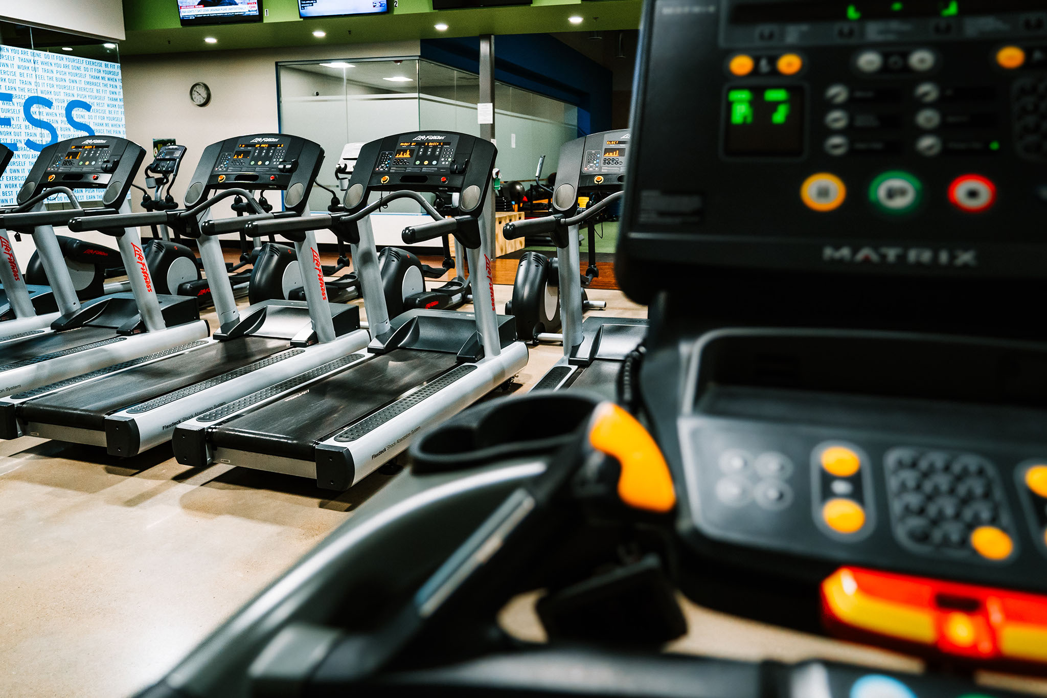 Treadmills and exercise bikes in a school gym.