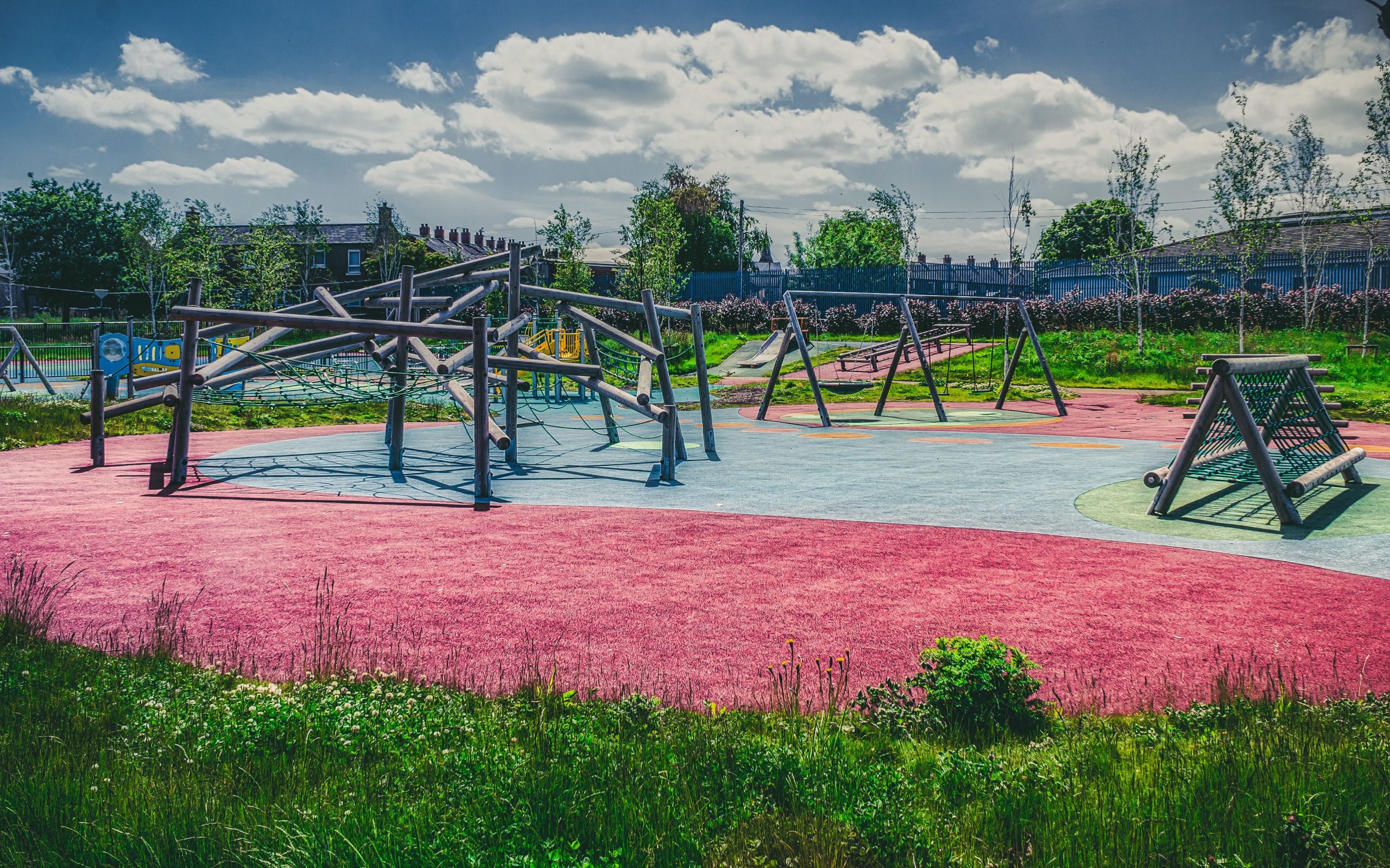 A school playground including climbing frames and swings.