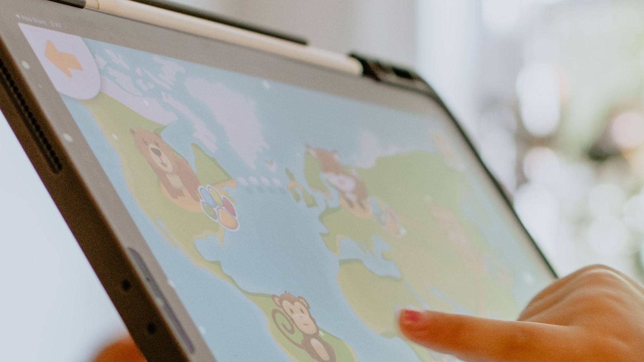 A primary school pupil points at a map on an iPad